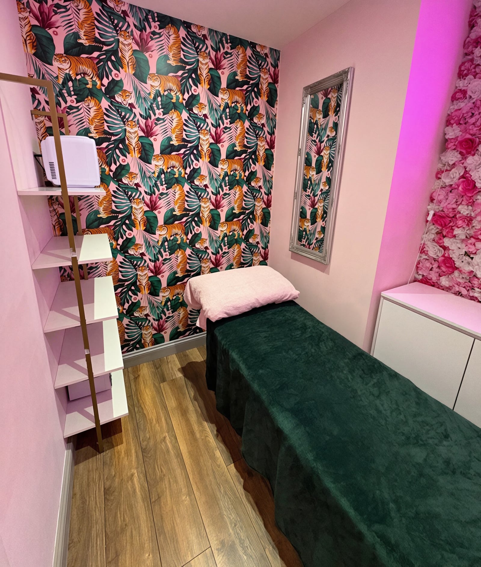 The pink treatment room with tiger wallpaper and floral wall