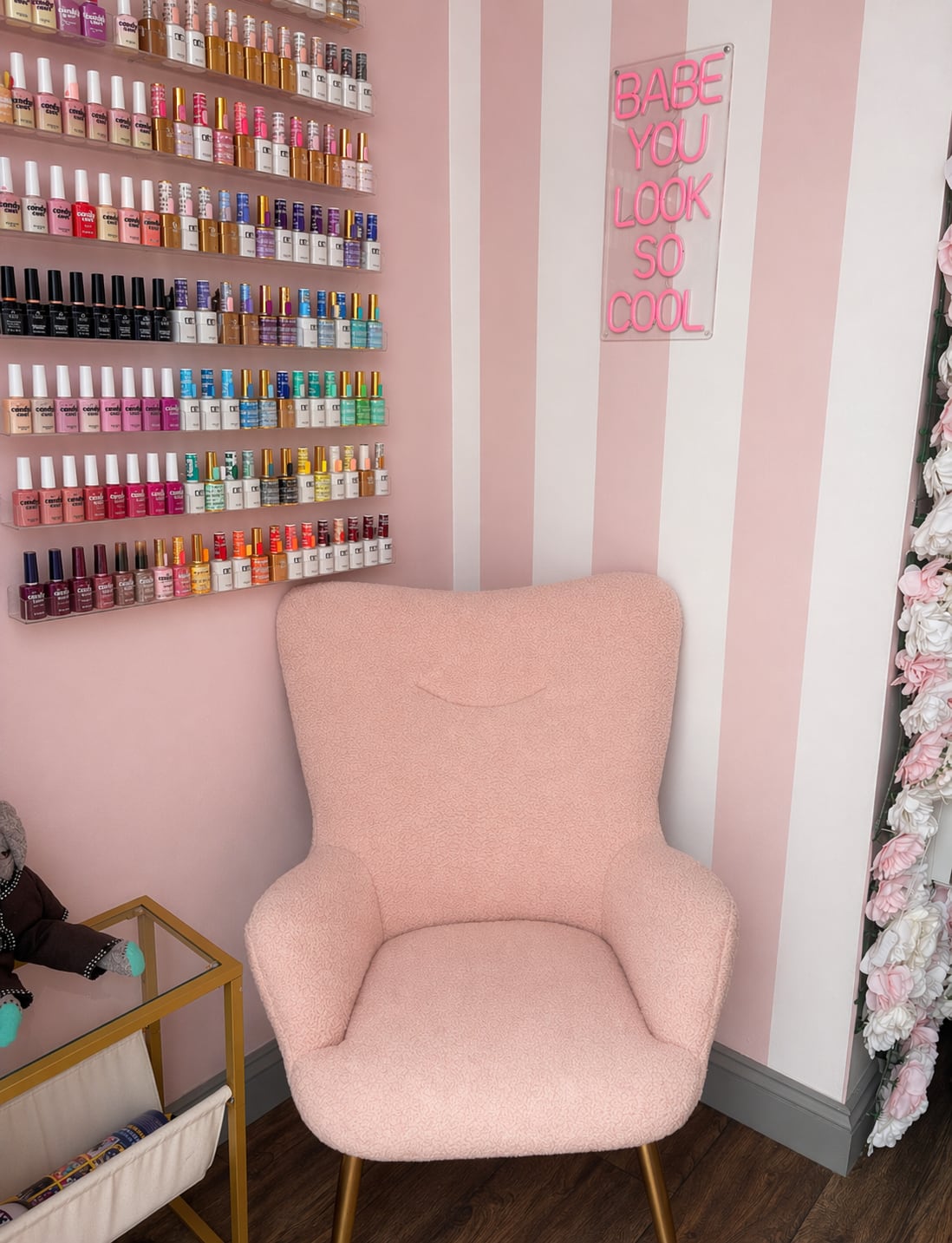 Pink pedicure chair beside a wall of nail colours
